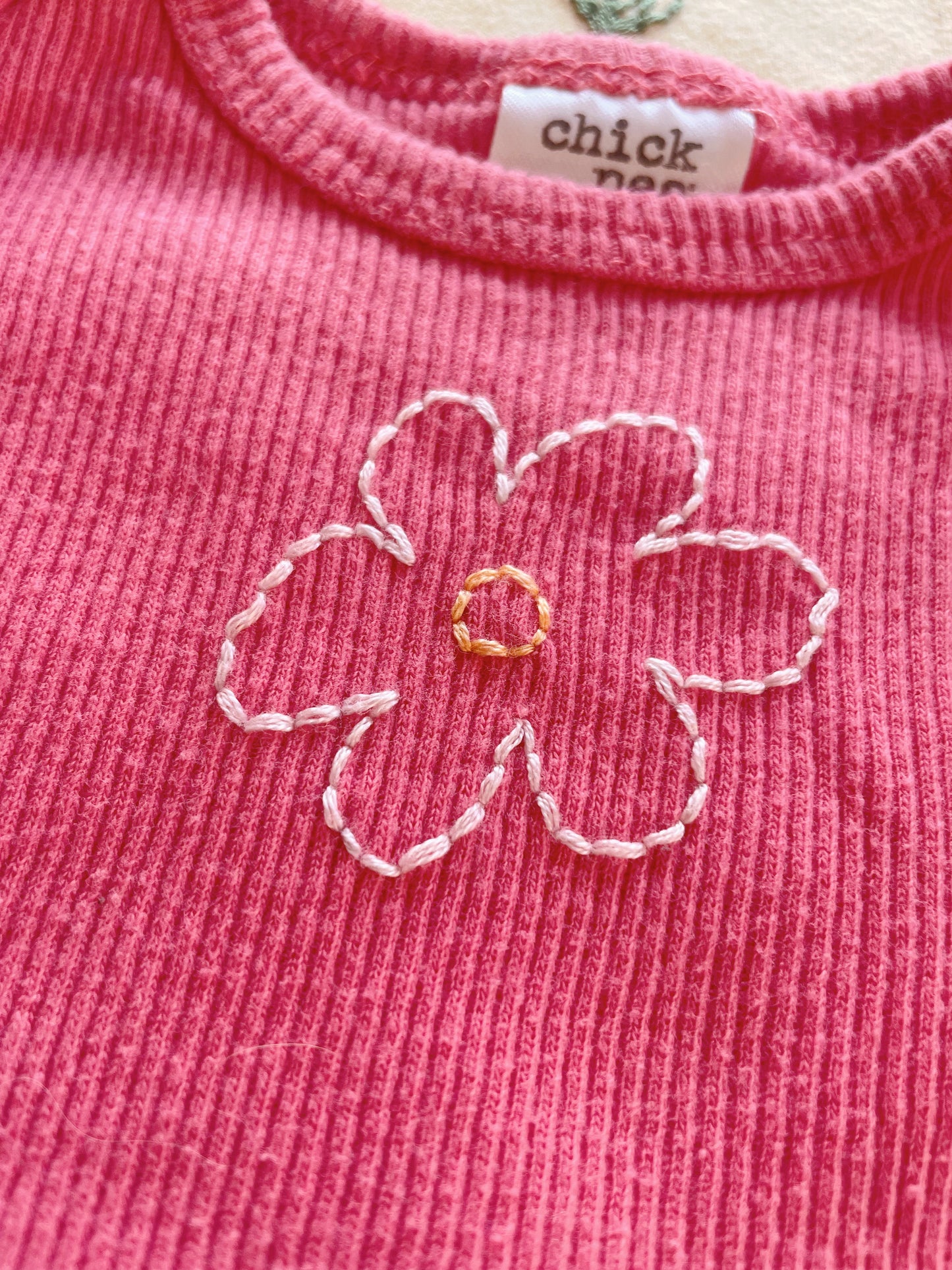 Flowers Hand embroidered on thrifted onesies